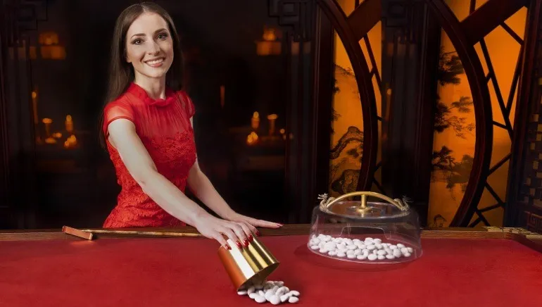 真人荷官操作番攤遊戲示意圖,展示番攤桌面與白色籌碼